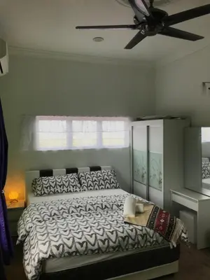 a bedroom with a bed and a ceiling fan at Bendang Homes - Sekinchan Homestay in Kampong Sungai Leman