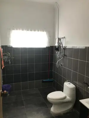 a bathroom with a white toilet and a window at Bendang Homes - Sekinchan Homestay in Kampong Sungai Leman