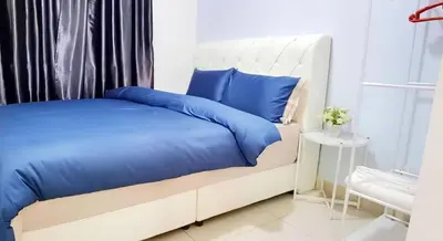 a bedroom with a bed with blue pillows at ROMANCE FULL HOUSE THREE PREMIER SUITE in Butterworth