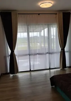 a bedroom with a large window with curtains at SBB Star Homestay in Sungai Petani