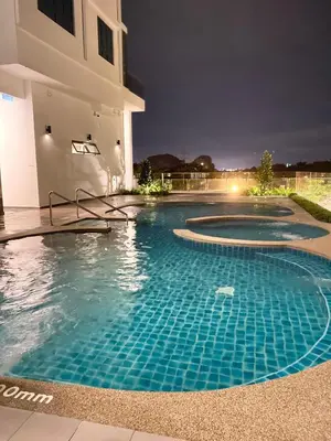 a swimming pool in front of a house at night at Sunway City Onsen COSY HOME Tambun Ipoh in Ipoh