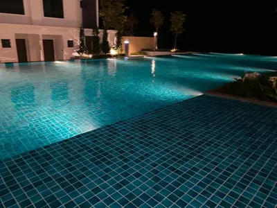 a swimming pool lit up at night at Sunway City Onsen COSY HOME Tambun Ipoh in Ipoh