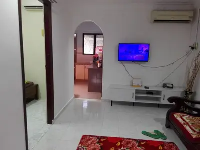 a living room with a tv on a white wall at Idaman guesthouse Malay FAMILY ONLY in Kubang Semang