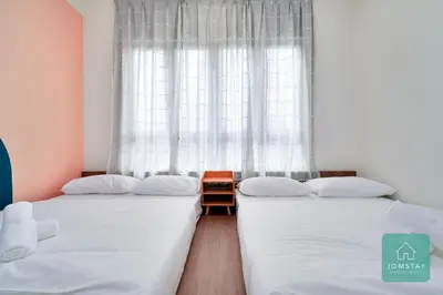 two twin beds in a room with a window at JOMSTAY Sunway Onsen Suites Ipoh - Lost World of Tambun Ipoh Waterpark in Tambun