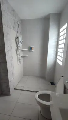 a white bathroom with a shower and a toilet at Gopeng Serumah Holiday House in Gopeng