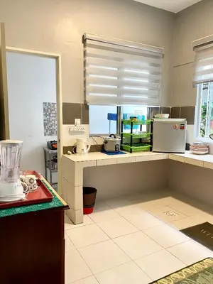 a kitchen with a counter and a window with blinds at LIYANA AAISYA HOMESTAY - 10 UNITs - JOINT VENTURE PARTNERS in Tanah Rata