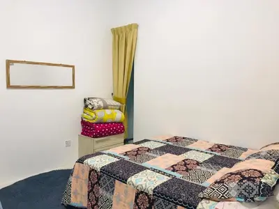 a bedroom with a bed with a quilt on it at LIYANA AAISYA HOMESTAY - 10 UNITs - JOINT VENTURE PARTNERS in Tanah Rata