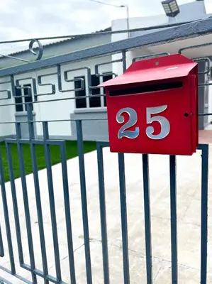 a red mailbox with the number on a fence at Roomah Istana in Ipoh