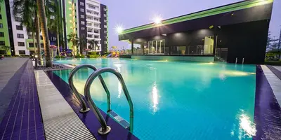 a large swimming pool in a city at night at Ipoh Homestay - Manhattan Condominium with Water Park & Leisure Facilities in Ipoh