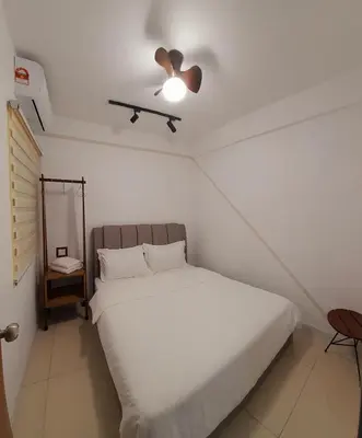 a bedroom with a white bed with a ceiling fan at Ipoh Homestay - Manhattan Condominium with Water Park & Leisure Facilities in Ipoh