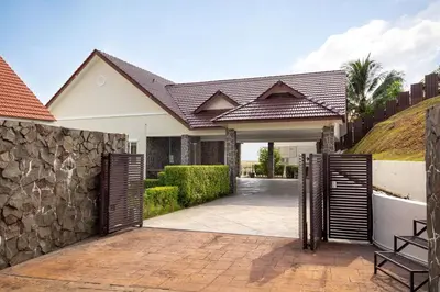 an open gate to a house with a stone wall at Panoramic Seaview Holiday Home - Batu Ferringhi in Batu Ferringhi