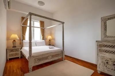 a bedroom with a canopy bed and a window at Panoramic Seaview Holiday Home - Batu Ferringhi in Batu Ferringhi