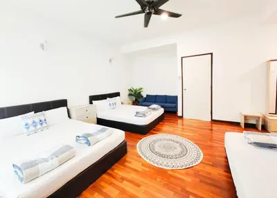 two beds in a room with wooden floors at Ocean 27 Batu Ferringhi Shamrock Beach 6 Bedroom 22pax with Pool in Batu Ferringhi