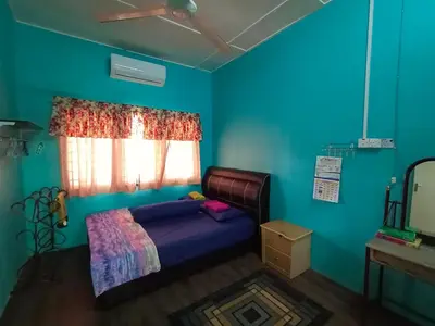 a bedroom with a bed and a blue wall at Hazaff Homestay in Sungai Petani