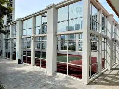 a tennis court inside of a building with windows at Lucky Waterfront at Straits Quay Seaview or Non in Bagan Jermal