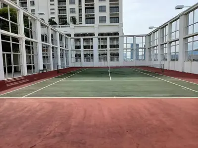 a tennis court in front of a building at Lucky Waterfront at Straits Quay Seaview or Non in Bagan Jermal