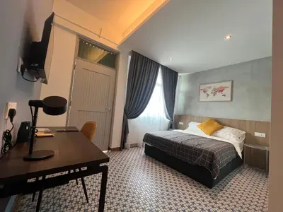 a hotel room with a bed and a desk and a desk at Ninety Guest House in Ipoh