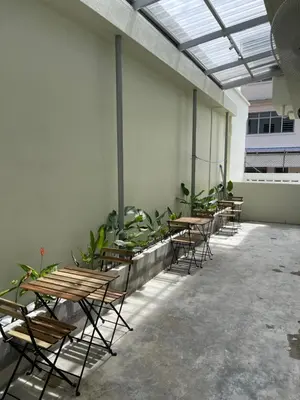 a group of tables and chairs in a room with plants at Ninety Guest House in Ipoh