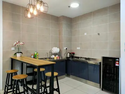 a kitchen with blue cabinets and a table and stools at Studio in Sunway Onsen @ Lost World of Tambun for 4 in Ipoh