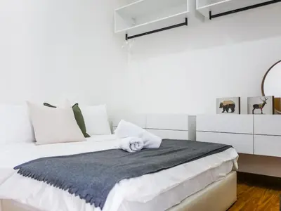 a white bedroom with a bed with a gray blanket at Beacon Executive Suites by S&F #InfinityPool #SkyGym in George Town