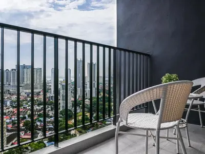 a balcony with two chairs and a view of a city at Beacon Executive Suites by S&F #InfinityPool #SkyGym in George Town