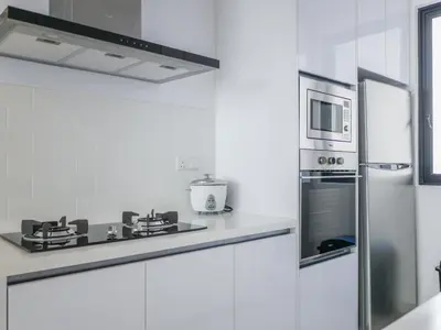 a white kitchen with a microwave and a stove at Beacon Executive Suites by S&F #InfinityPool #SkyGym in George Town
