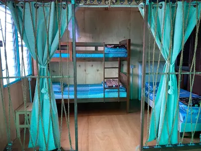 two bunk beds with blue curtains in a room at New Farmer Hut 1 in Brinchang