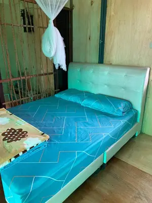 a bed in a room with a blue mattress at New Farmer Hut 1 in Brinchang