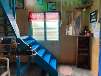 a room with a blue staircase and a window at New Farmer Hut 1 in Brinchang