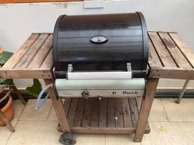 a grill sitting on a wooden picnic table at New Farmer Hut 1 in Brinchang
