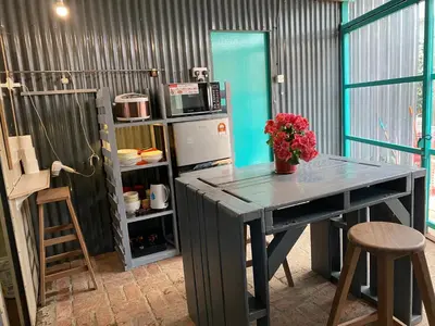 a kitchen with a table with a vase of flowers on it at New Farmer Hut 1 in Brinchang
