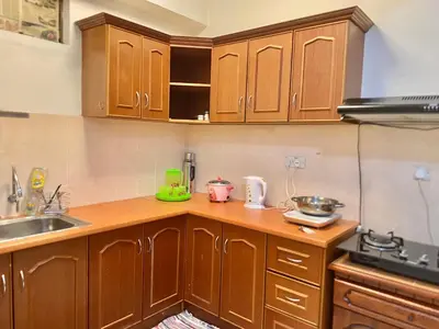 a kitchen with wooden cabinets and a sink at Homestay Legacy Kamariah Ahmad,Lumut in Lumut