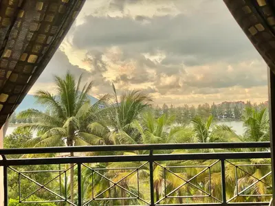 a view from the balcony of a resort with palm trees at Homestay Legacy Kamariah Ahmad,Lumut in Lumut