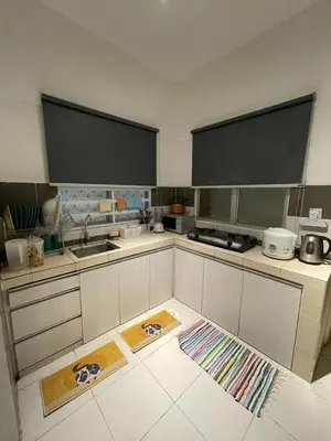a kitchen with white cabinets and a sink and a counter at Cameron Sweet Muslim Apartment 2 - Iiqoma Muslim Homestay in Tanah Rata