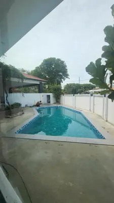 a large swimming pool with blue water in a yard at Fairy Retreat Private Pool Cottage IPOH, BBQ, KTV, 10-12 pax in Ipoh