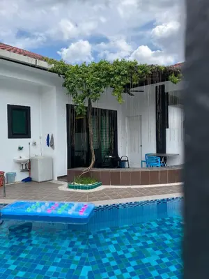 a pool in front of a house with a tree at Fairy Retreat Private Pool Cottage IPOH, BBQ, KTV, 10-12 pax in Ipoh