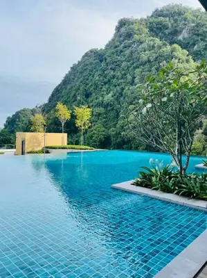 a swimming pool with a mountain in the background at Sunway Onsen Suite Tambun Ipoh Mountain View in Ipoh