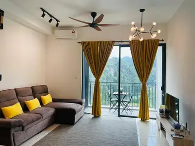 a living room with a couch and a large window at Sunway Onsen Suite Tambun Ipoh Mountain View in Ipoh