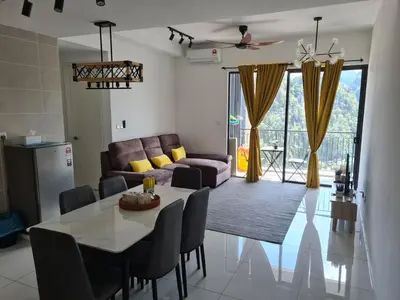a living room with a table and a couch at Sunway Onsen Suite Tambun Ipoh Mountain View in Ipoh