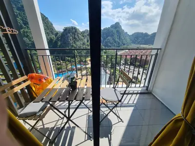 a balcony with chairs and a view of the mountains at Sunway Onsen Suite Tambun Ipoh Mountain View in Ipoh