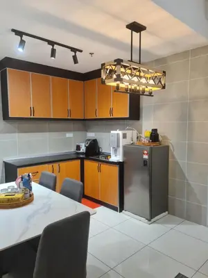 a kitchen with a table and a refrigerator at Sunway Onsen Suite Tambun Ipoh Mountain View in Ipoh