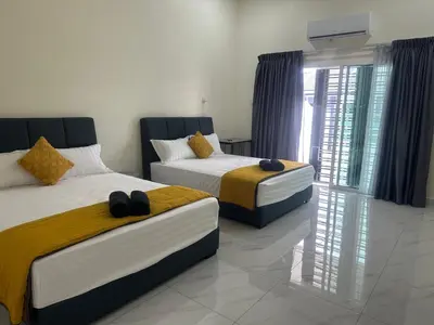 two beds in a room with a window at Jenny Homestay in Teluk Intan