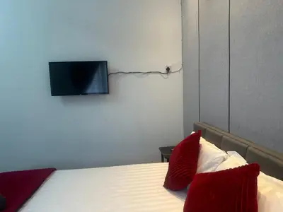 a bedroom with a bed with a tv on the wall at Jenny Homestay in Teluk Intan