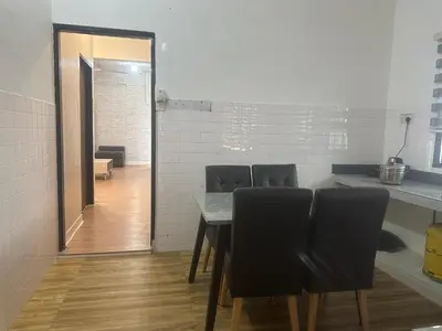 a dining room with a table and black chairs at Jenny Homestay in Teluk Intan
