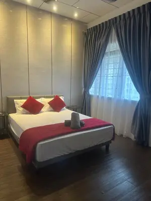 a bedroom with a large bed with red pillows at Jenny Homestay in Teluk Intan