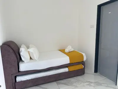 a bed with towels on it in a room at Jenny Homestay in Teluk Intan