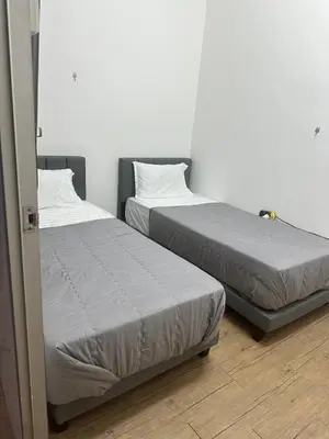two beds sitting next to each other in a room at Jenny Homestay in Teluk Intan
