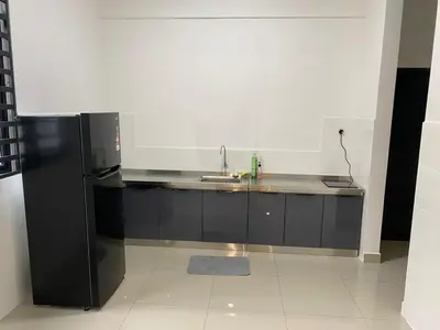 a kitchen with a sink and a black refrigerator at A Home - Homestay near St Anne Church Bukit Mertajam in Bukit Mertajam