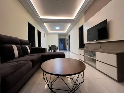 a living room with a couch and a table at StoberiCekelatHomestaymuslim's in Brinchang