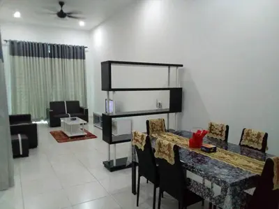 a dining room with a table and chairs and a living room at Percutian Di Taiping & Bukit Merah Laketown in Kamunting